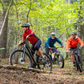 Tre stycken MTB cyklister kör genom skogen på Björnön