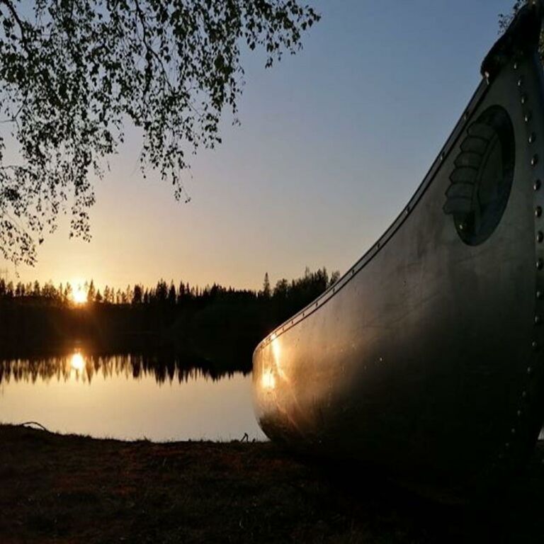 Canadensare uppdragen vid strandkanten vid solnedgång