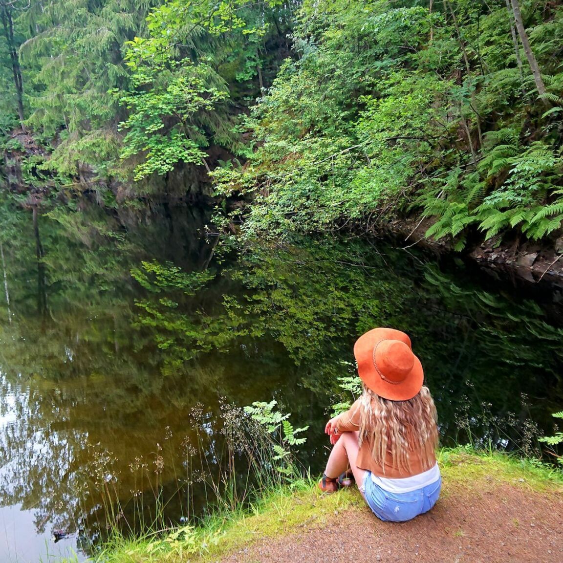 bild på kvinna som sitter med ryggen mot kameran vid Svinryggen och filosoferar